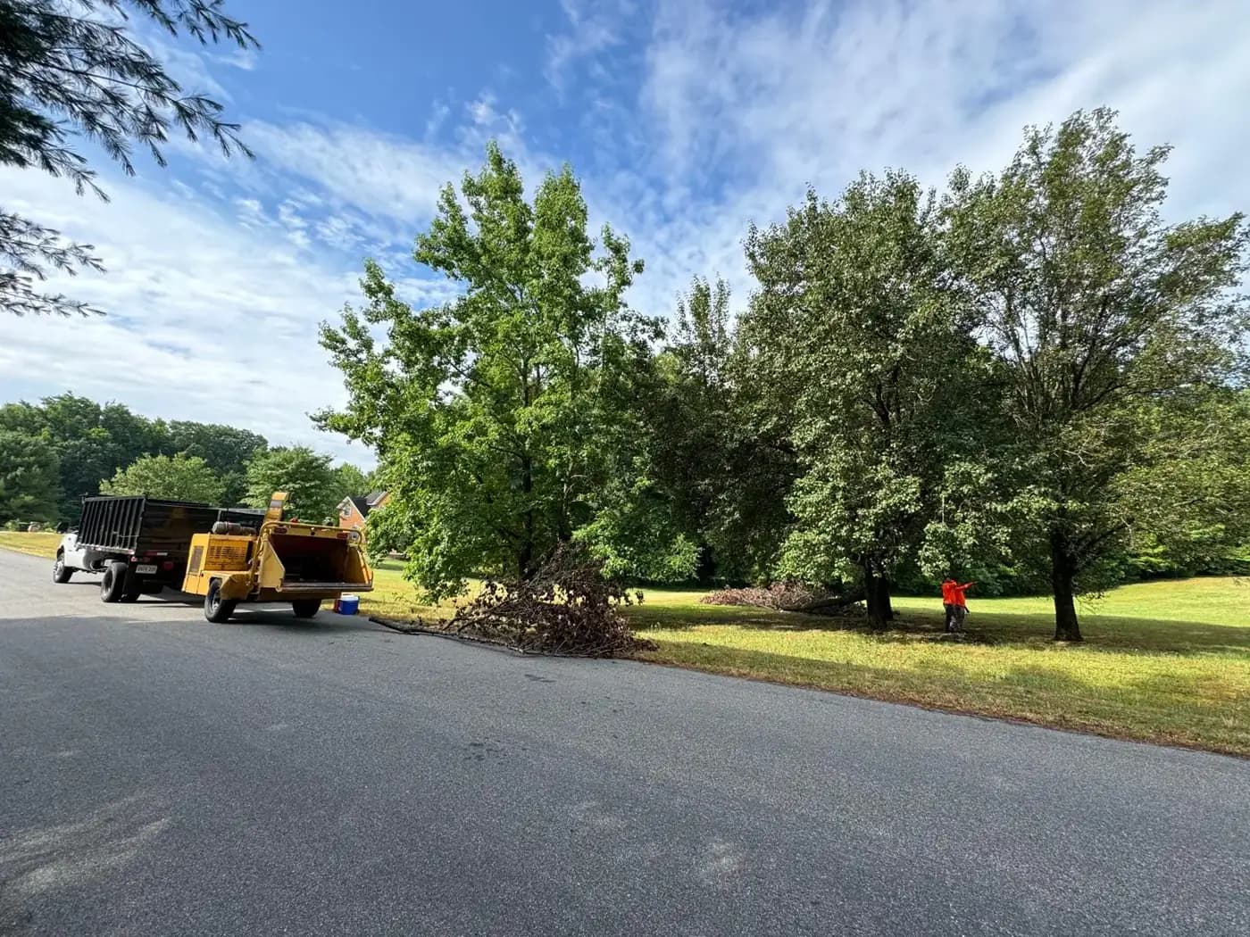 MG Tree Service dump truck and wood chipper at a job in Richmond, VA